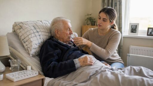 JUnge Enkeltochter pfleget pflegebedürftigen Opa häuslich.