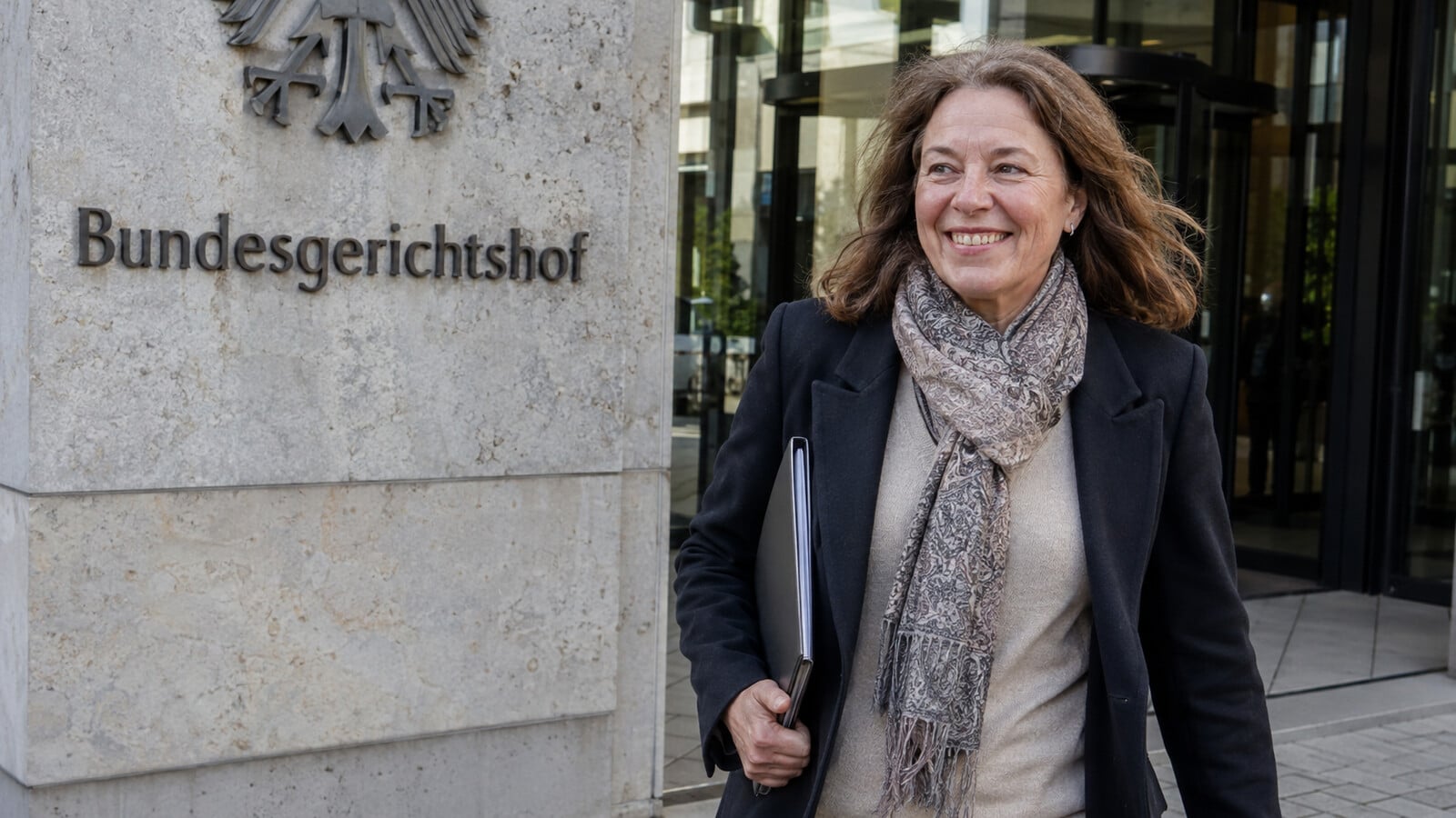 Erleichterte Frau vor dem Bundesgerichtshof nach gewonnenem Verfahren