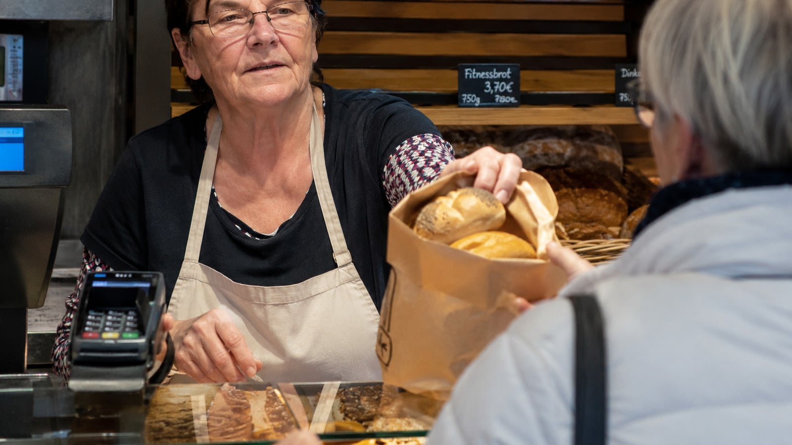 Minijobberin arbeitet an der Verkaufstheke einer Bäckerei